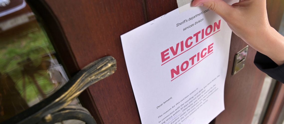 Civil servant sticks a notice of eviction of the tenant, close up